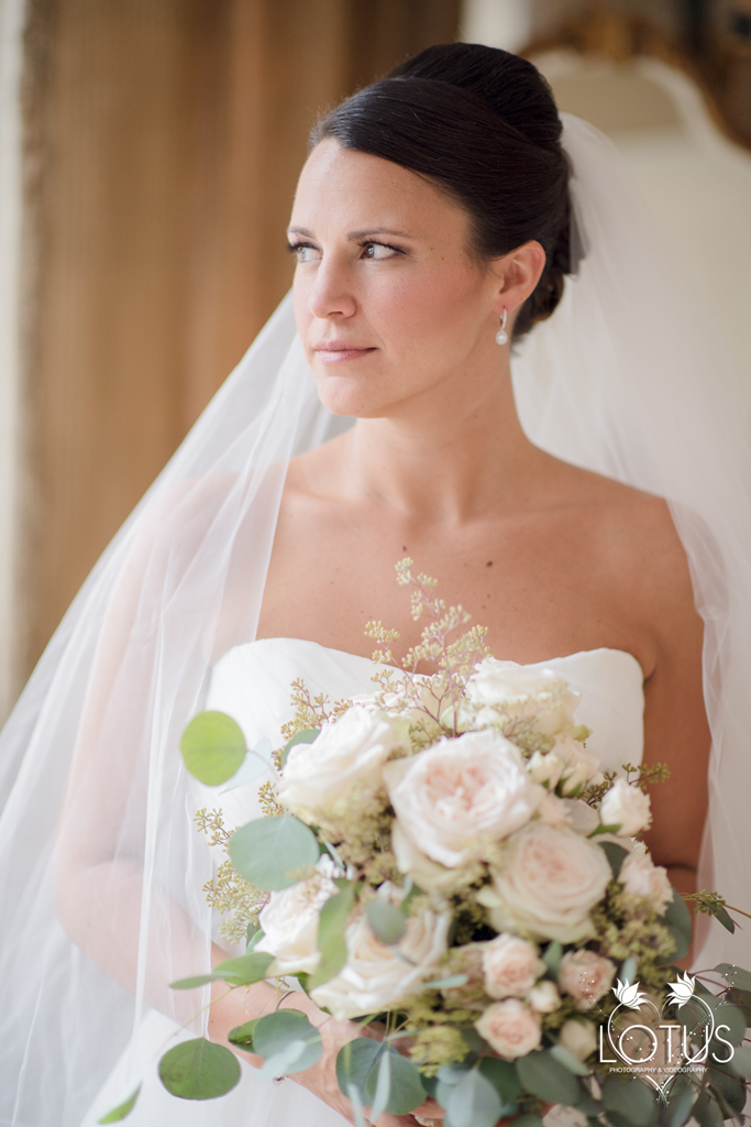 Bride with updo holding a bouquet.