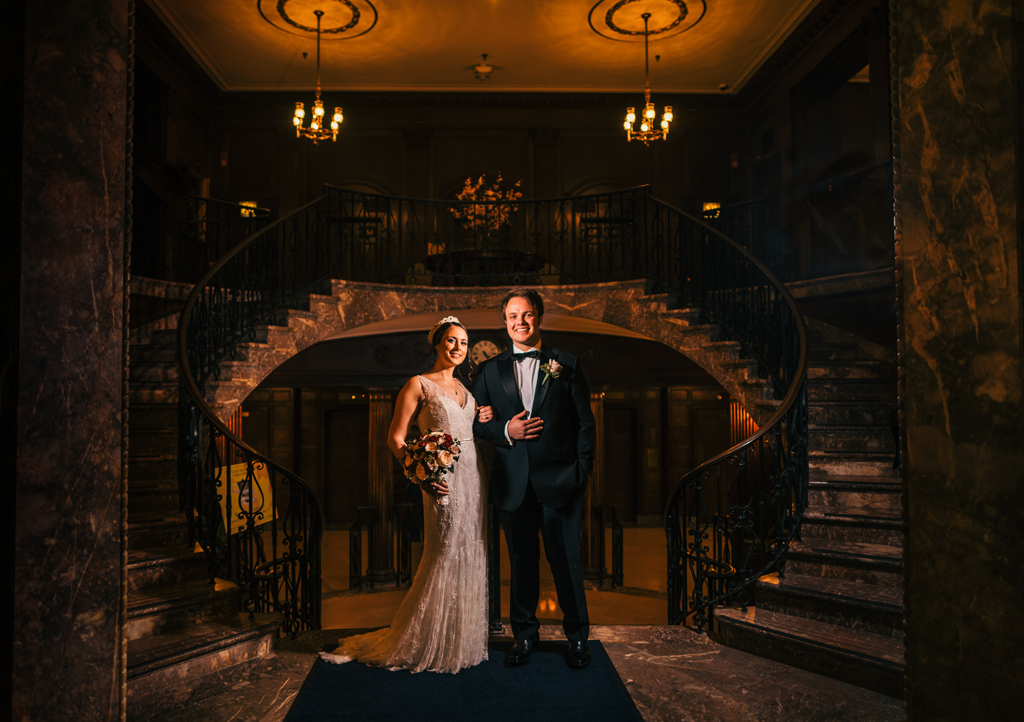 Wedding bride and groom at center of double stairway. 