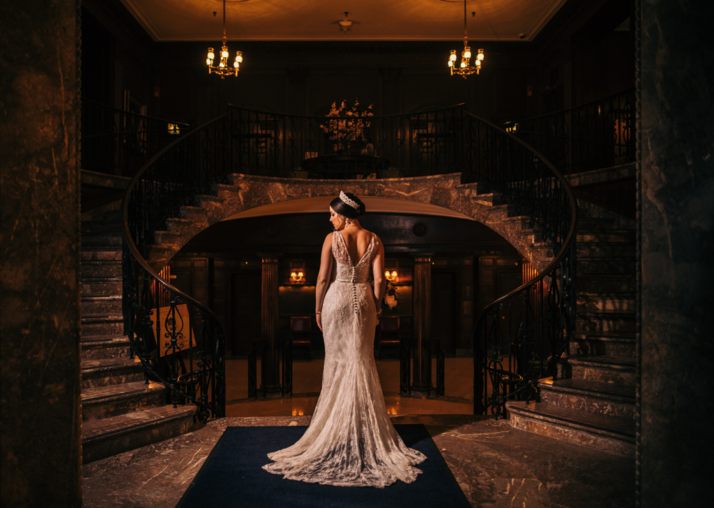 Bride facing away at center of classy stairway.