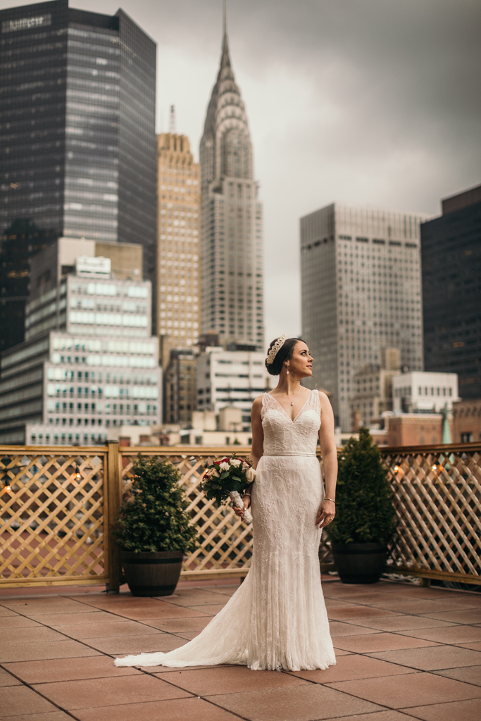 Bride on rooftop looking away at New York City.